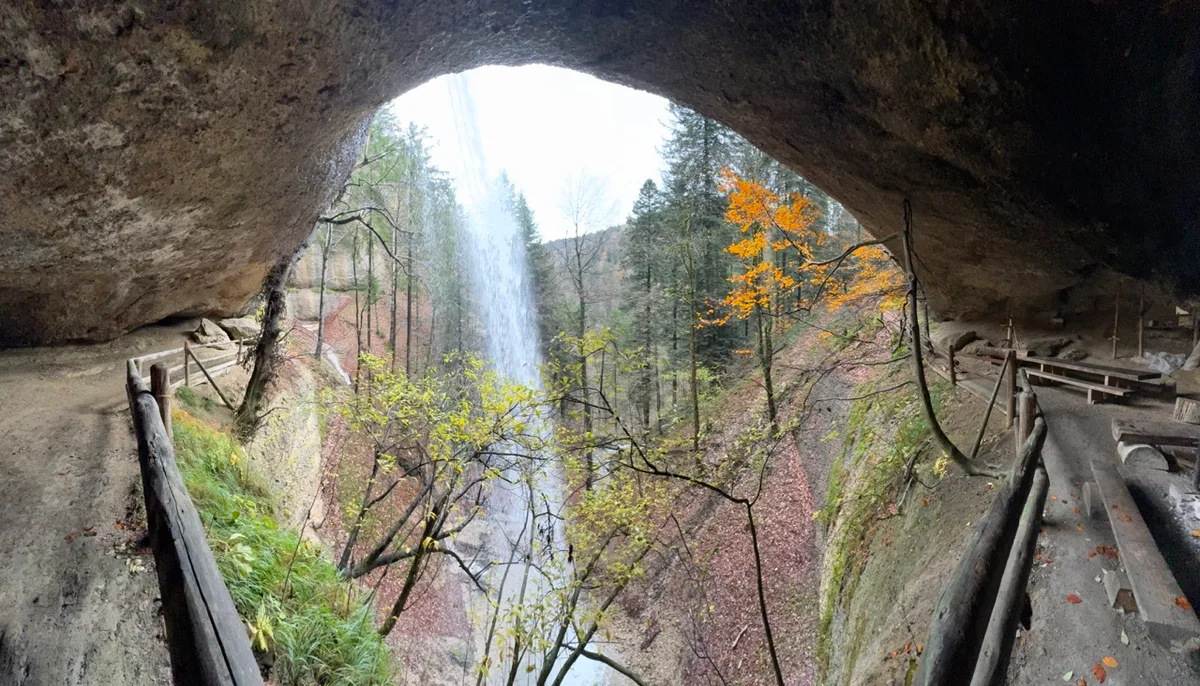 Die Höhle ist mit festen Sitzbänken ausgestattet. Für die Feuerstellen steht jederzeit Holz zur Verfügung. Ob sich hier einst ein Schatz befand? Der Ausblick aus einer Höhle mit Wegen und Sitzbänken.